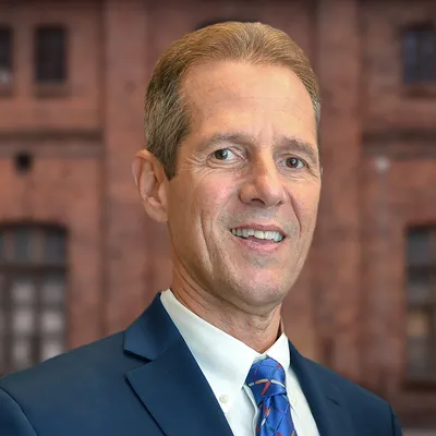John Cranias, Settlement Consultant at Brant Hickey Orlando, standing in front of a brick wall