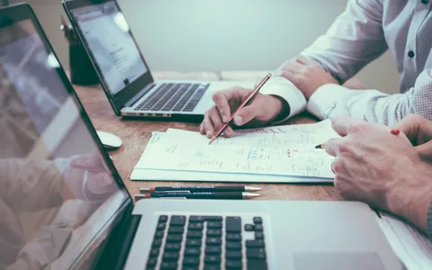 Two computer screens side by side comparing qualified and non-qualified settlement options