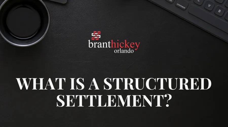 A notepad reading "What is a structured settlement?" beside a pen and calculator